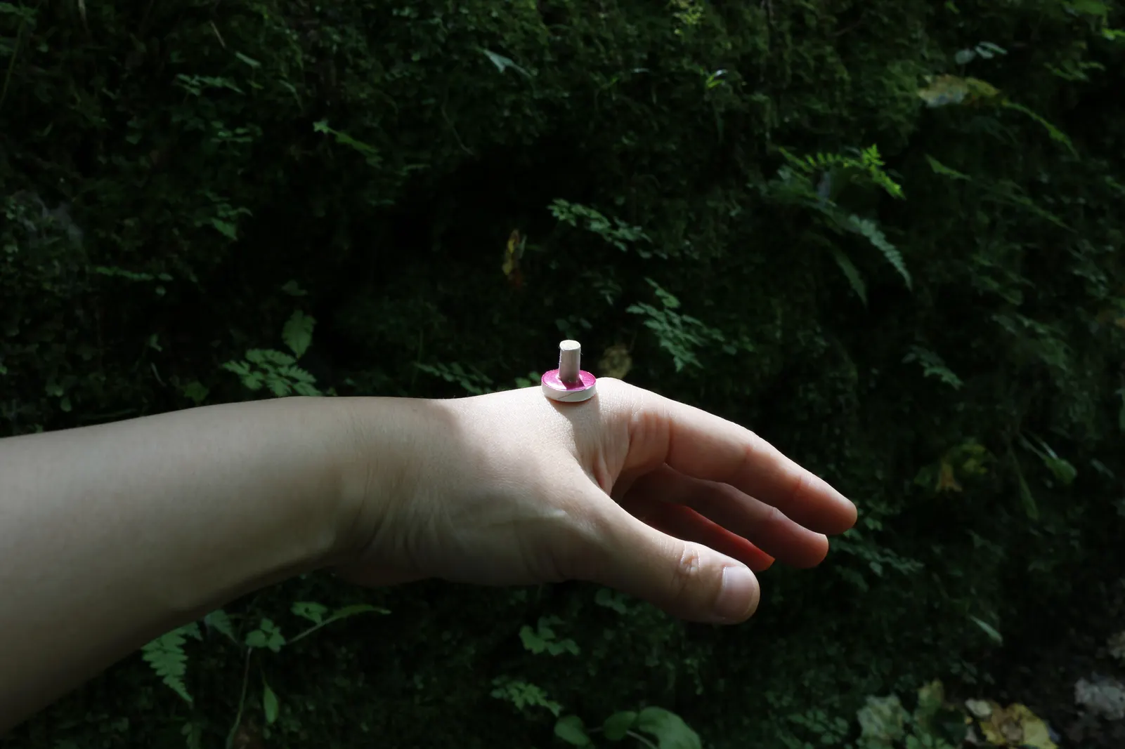 A moxa stick on a small base resting on the back of a hand